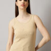 Female model wearing a ribbed tank top in Skin color, posing in a studio setting with a neutral background.